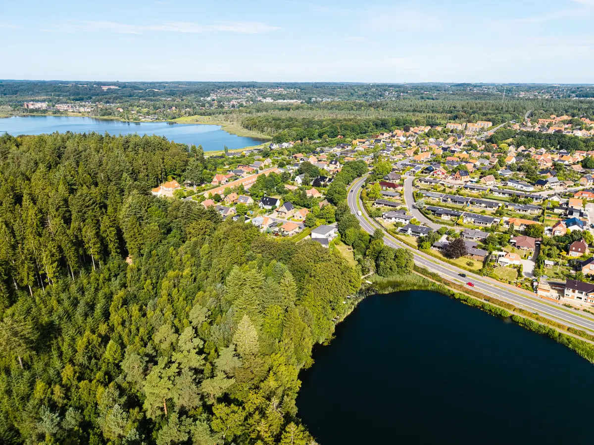 Luftfoto af by, skov og søer