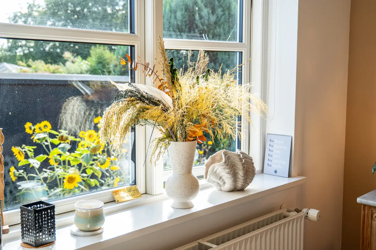 Vindueskarm med tørrede blomster i en vase