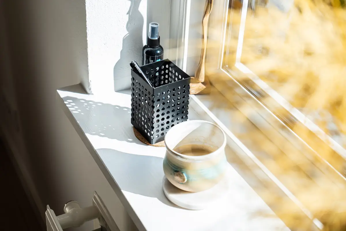 Vindueskarm med kop og krus i sollys