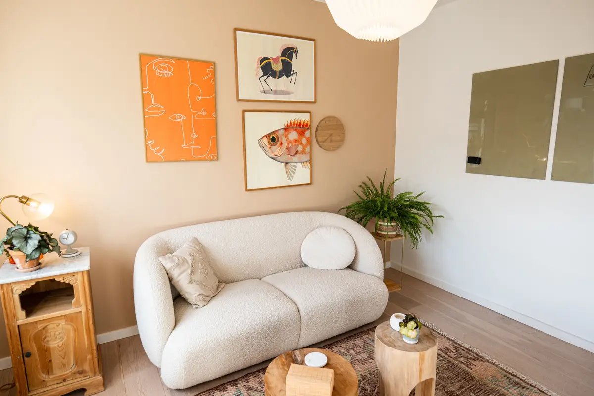 Lyst rum med hvid sofa og kunst på væggen